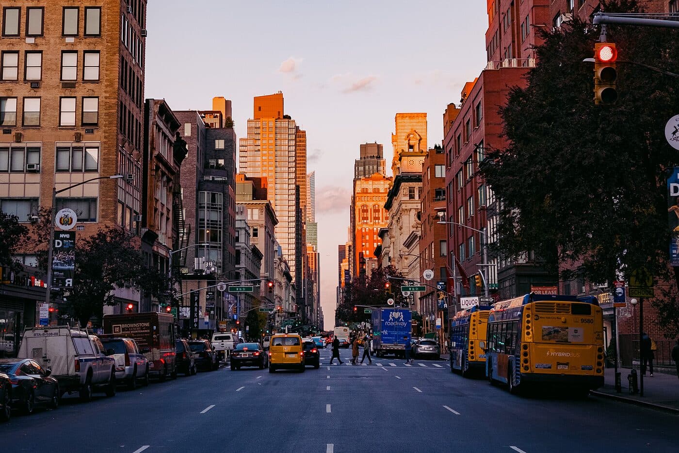 A wide avenue at sunset, low light catching the buildings at the far end