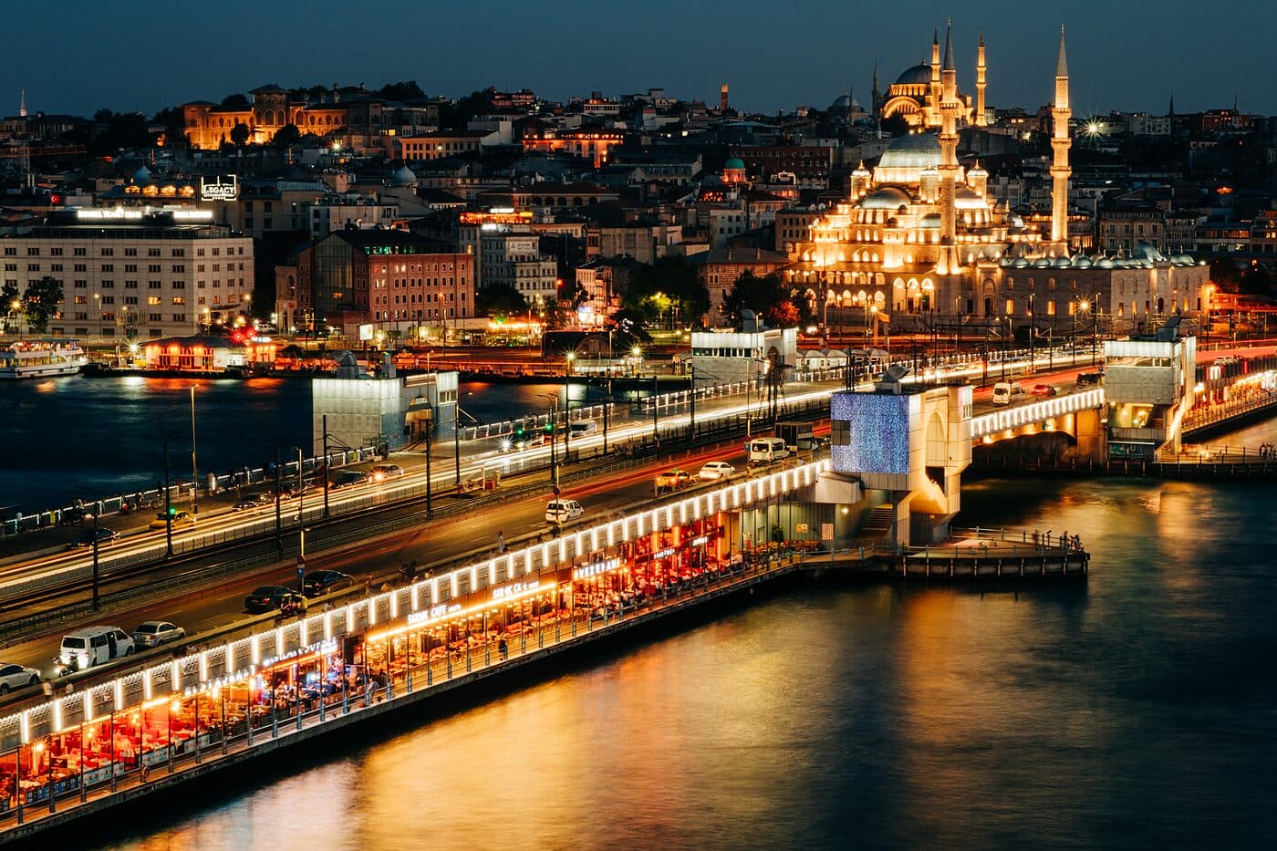 A lit waterfront and a domed skyline across the water at night