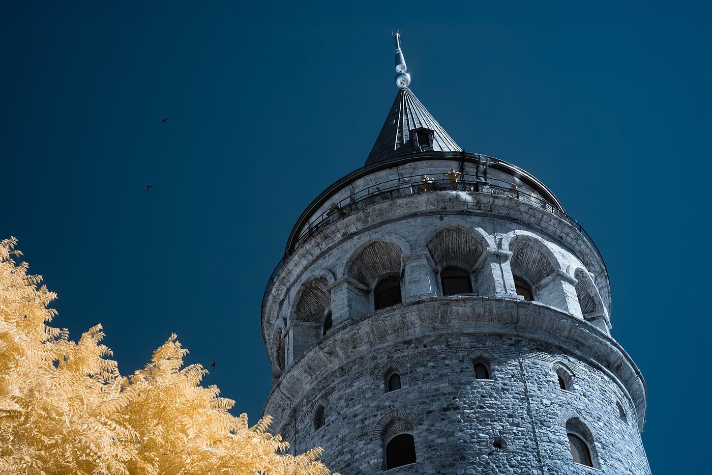 A stone tower with a conical roof against a deep blue sky